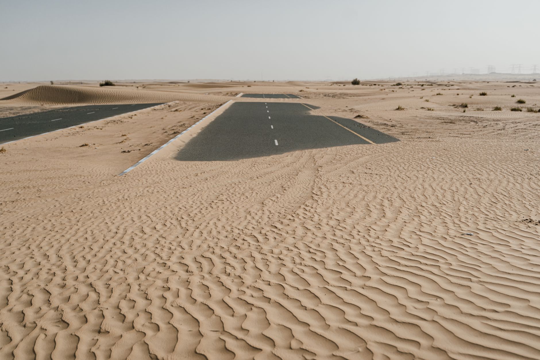 Empty road through desert dunes