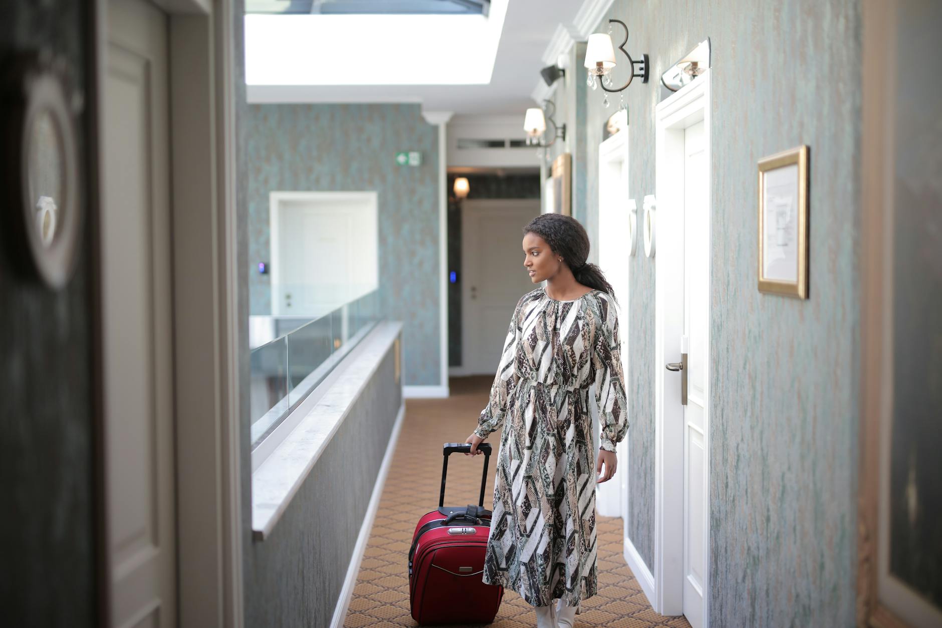 Traveller wheeling a luxury suitcase along a hotel hallway