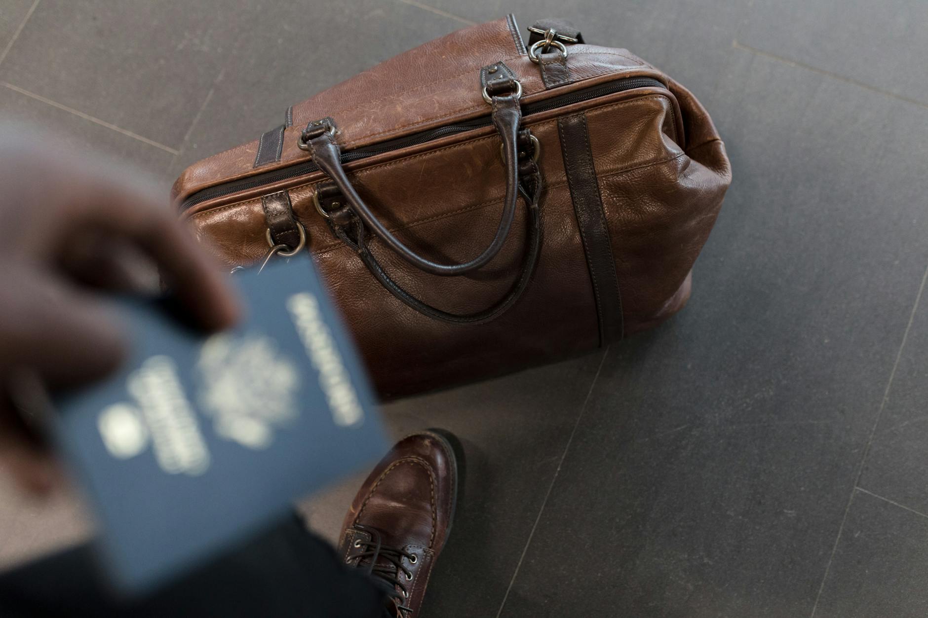 Premium suitcase and passport at an airport boarding gate