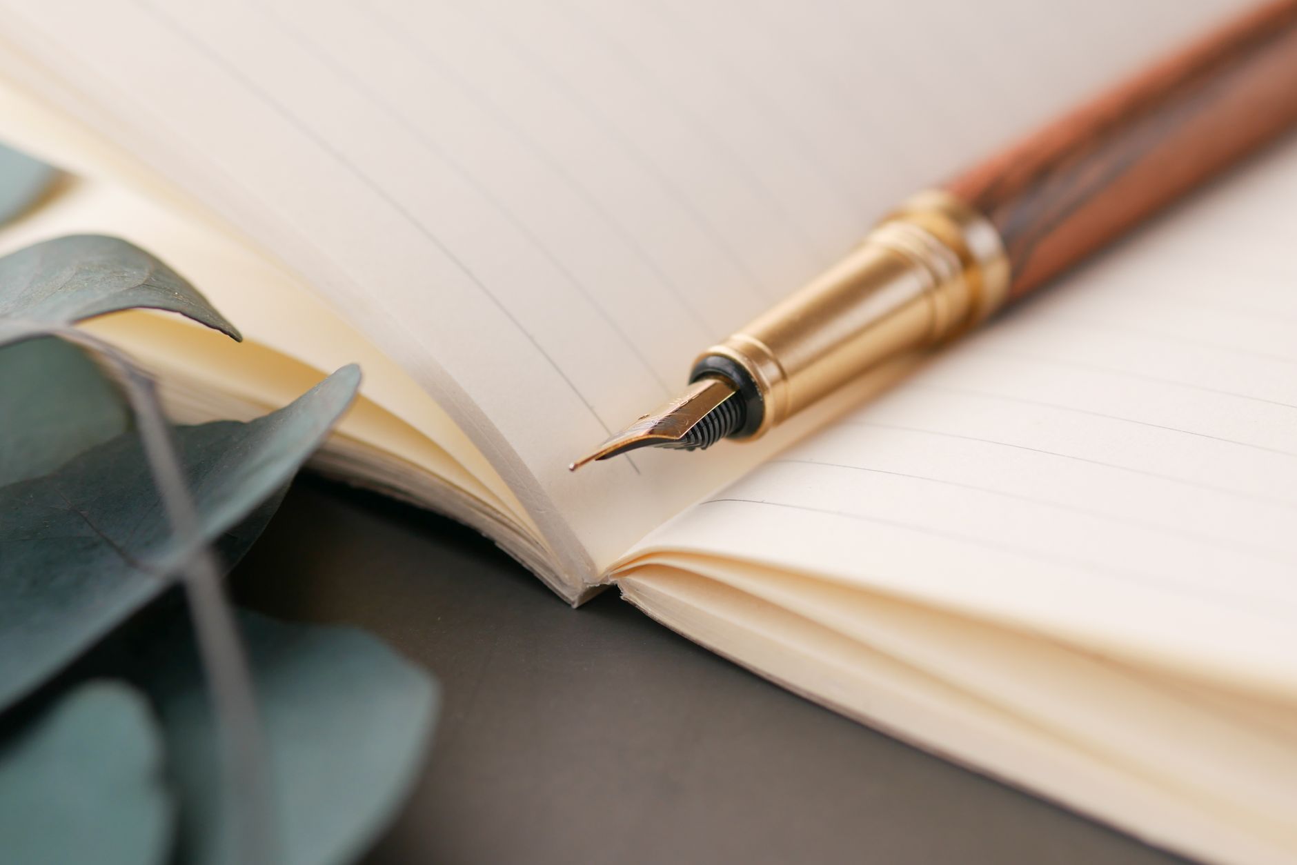 Fountain pen resting on a notebook on a polished desk