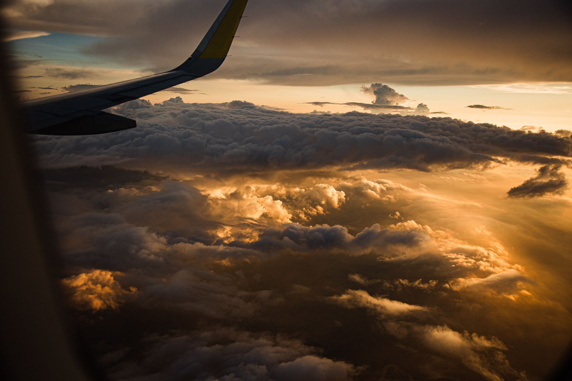 View of an aircraft wing above the clouds at sunset