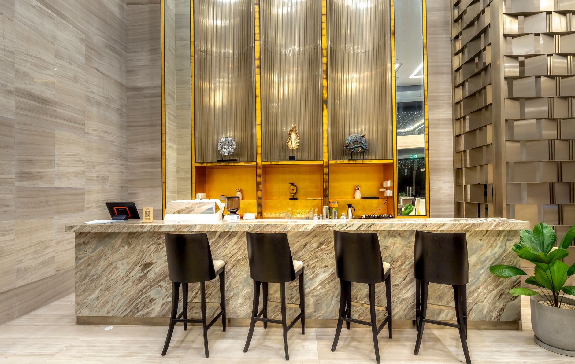 An upscale hotel lobby bar with a marble counter and brass detailing, illustrating a hotel-loyalty co-branded credit card.