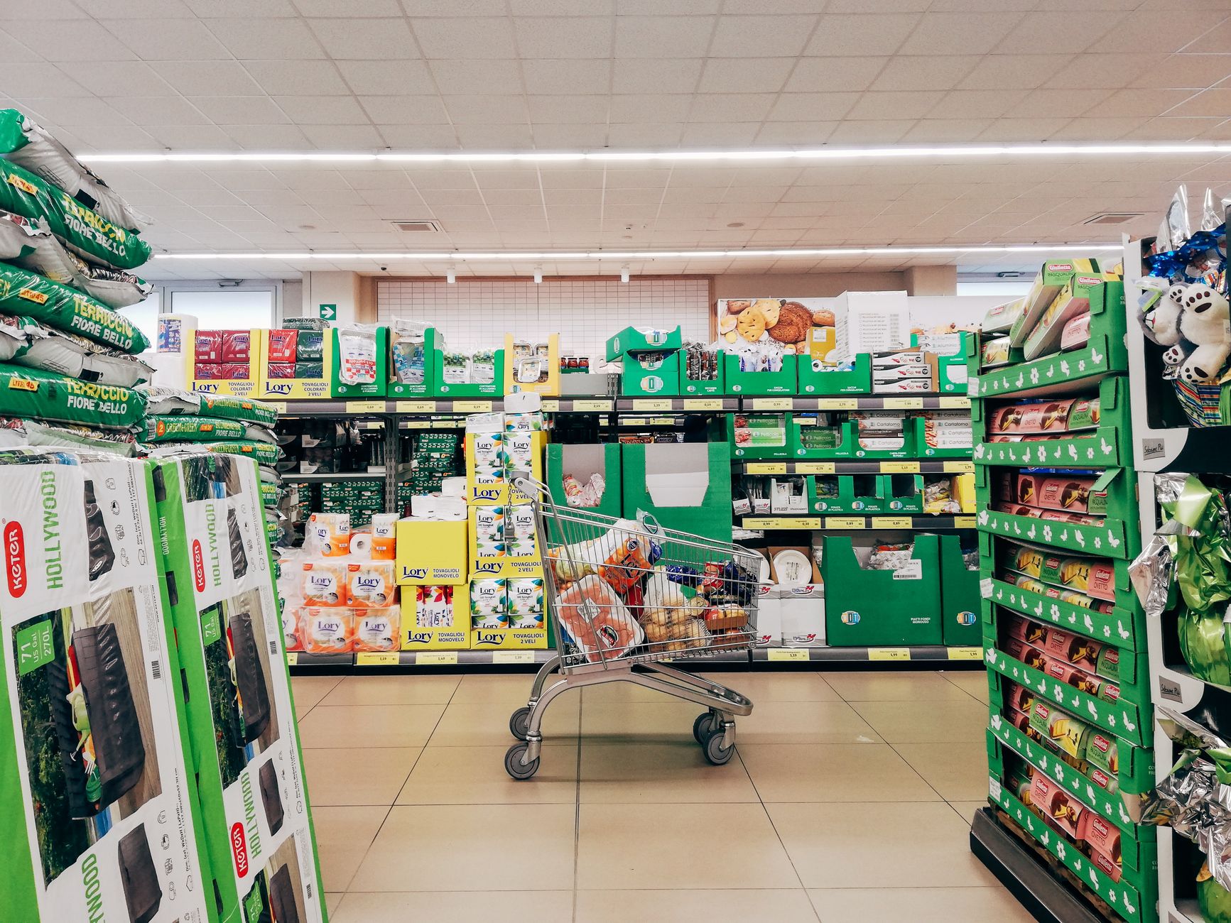 A shopping trolley of groceries in a supermarket aisle
